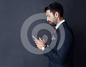 Must have technology for the modern exec. Studio shot of a businessman using a digital tablet against a gray background.