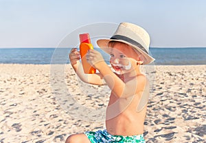 The mustache drawing sunscreen on baby (boy) face. photo