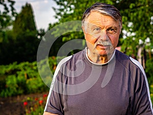 Mustachioed, unshaven old man resting in the Park