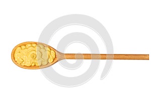 Mustard sauce in small wooden spoon isolated on white background,top view