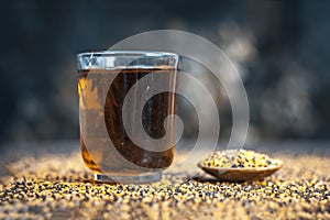 Mustard seed extracted tincture in a glass bowl on wooden surface.
