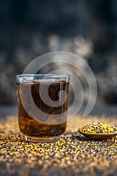 Mustard seed extracted tincture in a glass bowl on wooden surface.