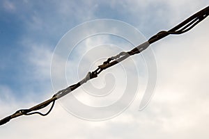 Musty electrical cables in blue sky background