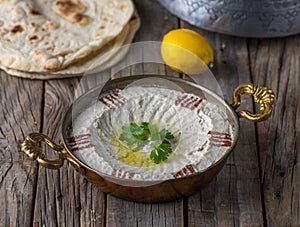 Mutabal served in a dish side view on wooden table background