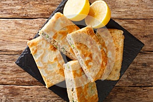 Mutabbaq is an Arabic bread with egg and spicy meat filling closeup in the board. horizontal top view