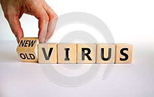 Mutated covid virus symbol. Male hand turns a cube and changes words `old virus` to `new virus`. Beautiful white background. photo