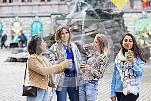 Muti ethnic group of female friends having fun drinking cocktails outdoor in the city in bar restaurant