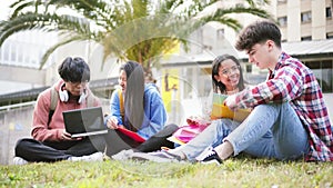 A mutiethnic group of two young boys and two student girls studying with the notebook and laptop the lesson of the high