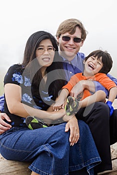 Mutiracial family sitting on beach