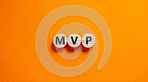 MVP, minimum viable product symbol. Wooden circles with the word MVP, minimum viable product. Beautiful orange background.
