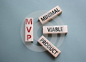 MVP - Most Valuable Player symbol. Wooden cubes with words MVP. Beautiful grey green background. Business and MVP concept. Copy