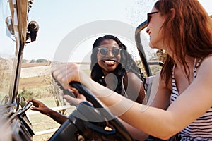 My best friend makes long car rides bearable. two smiling young woman taking a roadtrip together.