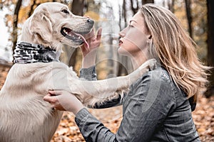 My best friend.Portrait of beautiful woman stroking the dog in the autumnal park