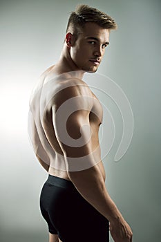 My body is my brand. Studio portrait of a muscular young man posing against a grey background.