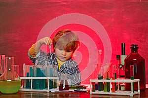 My chemistry experiment. Cheerful smiling little boy having fun against blue wall. Learning at home. School chemistry