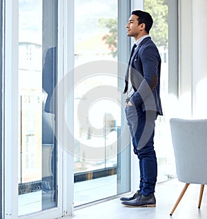 My city needs me. a businessman looking out his office window.