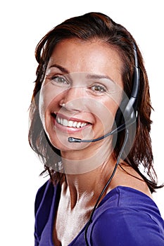 My customer service smile. Studio portrait of a woman in her mid-30s wearing a headset and smiling widely at the camera.