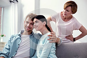 Pleasant happy man hugging his wife