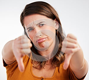 My energy level today. Studio shot of a young woman showing thumbs down against a white background.