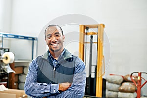 My factory floor is a well-oiled machine. Portrait of a smiling factory worker.