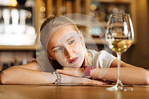Depressed sad woman looking at the glass of wine