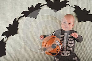 My first Halloween. Small child and pumpkin. Autumn concept, halloween, bats, pumpkins, newborn close-up and copy space