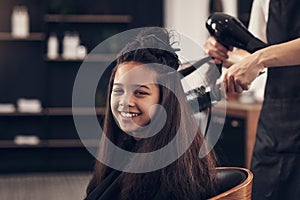 This is my first of many trips to the salon. a woman blowdrying her clients hair in her salon.