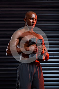 My focus is unmatched. Studio shot of an athletic young man working out using dumbbells against a grey background.