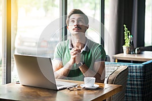 My God please help me. Young worry businessman in green t-shirt sitting looking up, praying and hope for help and forgiveness