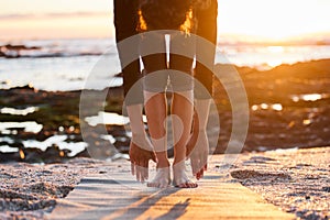 My hamstrings needed this stretch. Cropped shot of an unrecognizable woman doing yoga alone on the beach at sunset.