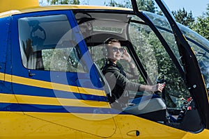 Beautiful female pilot sitting in helicopter photo