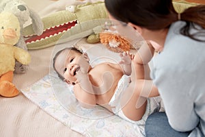 My little girl with the biggest smile. a woman changing her adorable baby girls diaper at home.