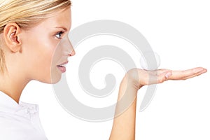 This is my lucky ball. Profile view of a young female golfer holding a golf ball in her palm isolated on white.