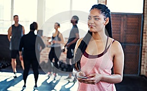 My mind is on training at the moment. a cheerful young woman standing and using her cellphone while contemplating before