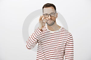 My mouth is fortress, count on me. Portrait of serious funny caucasian man in glasses, making gesture with hand, zipping