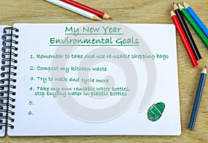 My New Year Environmental Goals heading with list of environmentally friendly ideas written in journal. New year environmental