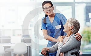 She is my number one priority. a young female nurse and her senior patient in the old age home.