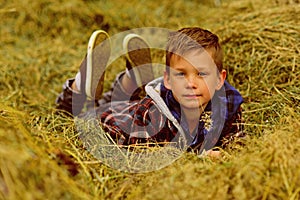 My own pleasure. Little boy relax on wheat field. Little boy on farm field. Cultivating and growing wheat. Enjoying