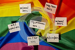 MY PRONOUNS ARE Neo pronouns concept. Rainbow flag with paper notes text gender pronouns hie, e, ne, xe, ze, tey. Non
