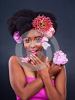 My secret is out. Studio shot of a beautiful young woman posing with flowers in her hair.