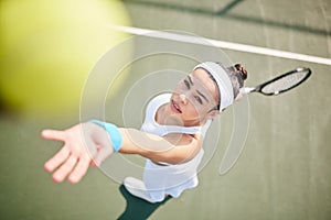 My serve needs to be perfect. High angle shot of young tennis player standing alone on the court and serving the ball