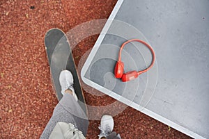 Man standing with one leg at the skate and preparing to taking his headphones