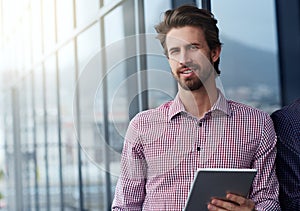 My tablet is a portable desk. Portrait of a young businessman using a digital tablet outside of an office building.