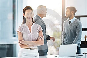 My team will get the job done. Cropped portrait of a businesswoman standing in the office with her colleages in the