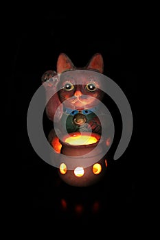 My terracotta beckoning cat by candlelight