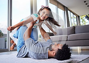 My time to fly. a young father playing with his daughter at home.