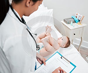 Are those MY toes. Shot of a paediatrician completing paperwork during a checkup.