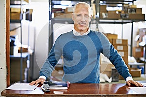 My warehouse is a well-oiled machine. Portrait of a mature man standing at a counter in a warehouse.