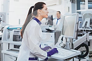 Attentive lab assistant working at computer