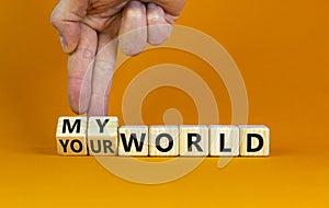 My or your world symbol. Businessman turns wooden cubes and changes words `your world` to `my world`. Beautiful orange table,